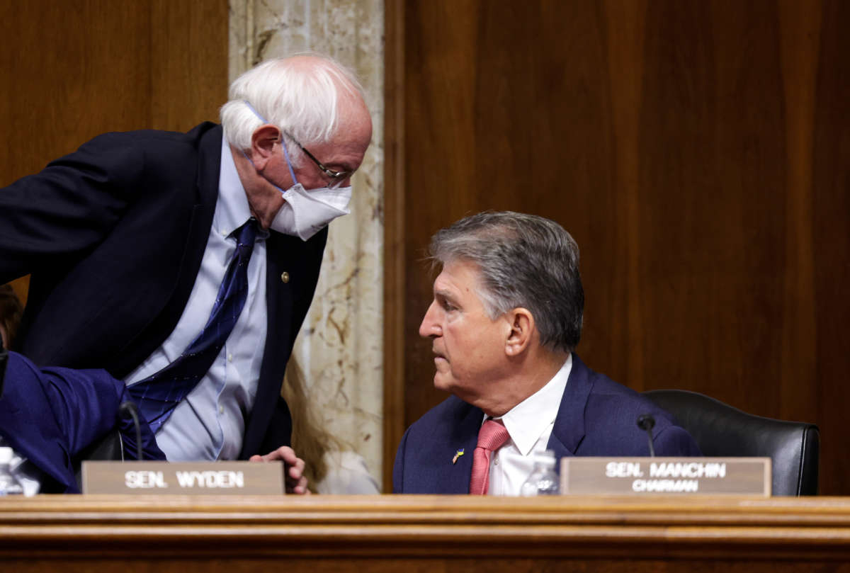 Sen. Bernie Sanders, left, walks past Sen. Joe Manchin during a Senate Energy and Natural Resources Committee mark up on Capitol Hill on May 3, 2022, in Washington, D.C.