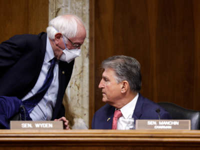 Sen. Bernie Sanders, left, walks past Sen. Joe Manchin during a Senate Energy and Natural Resources Committee mark up on Capitol Hill on May 3, 2022, in Washington, D.C.