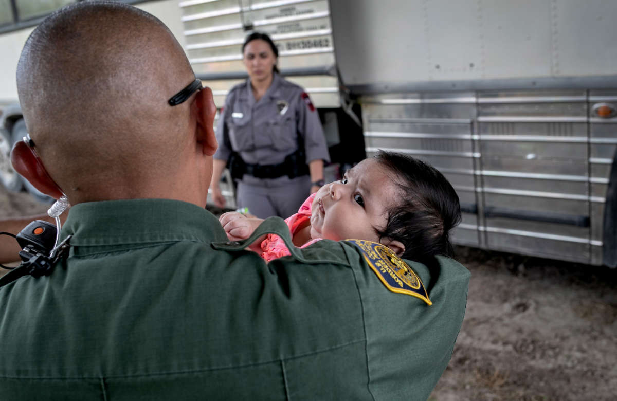 A U.S. Border Patrol agent holds an infant after she and her mother were taken into custody by U.S. Border Patrol agents on July 2, 2019, in McAllen, Texas.