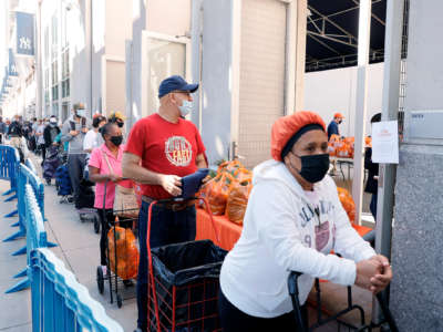People wait in line to receive food assistance