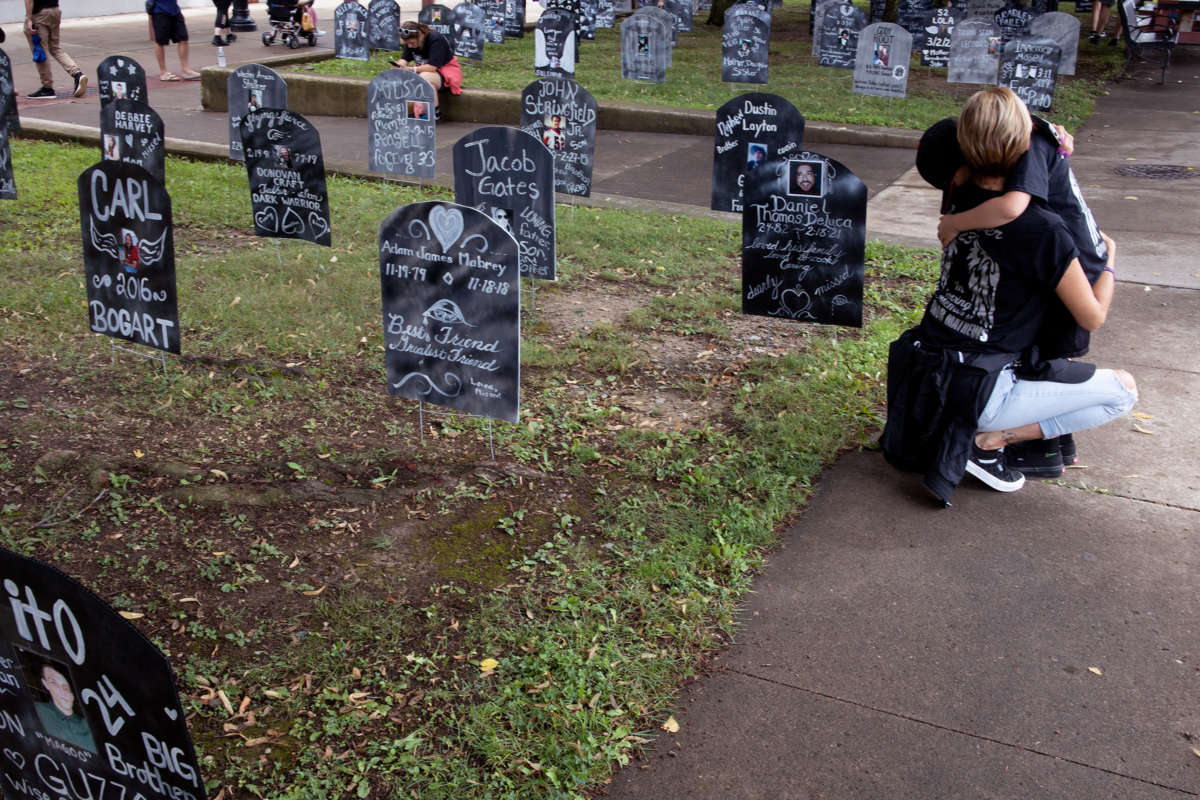 A person embraces a child at a memorial for victims of the opoid crisis