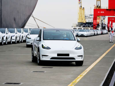 A fleet of tesla cars sit at a dock