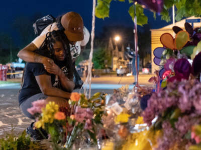 Two people embrace eachother at a streetside memorial for the victims of the racist Buffalo, New York, shooting