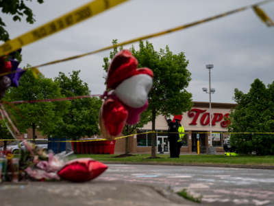 People gather at the scene of a mass shooting at Tops Friendly Market at Jefferson Avenue and Riley Street on May 16, 2022, in Buffalo, New York.