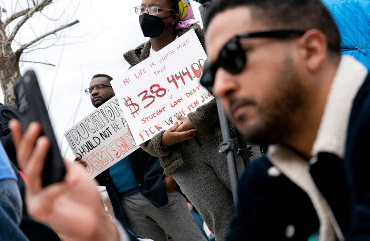 People hold signs during a Cancel Student Debt rally outside the U.S. Department of Education in Washington, D.C., on April 4, 2022.