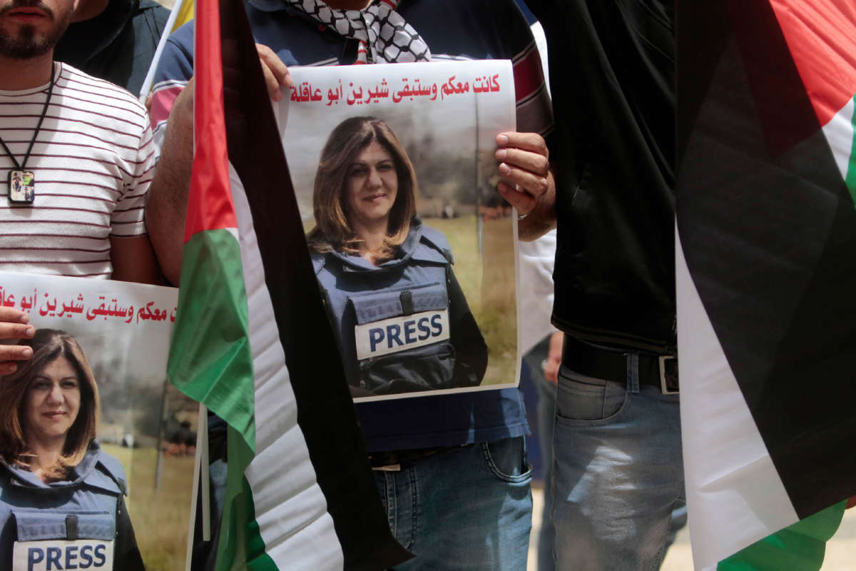 A Palestinian student holds a picture of Al Jazeera reporter Shireen Abu Akleh during a protest condemning her murder at the Al-Quds Open University in the city of Nablus in the occupied West Bank on May 14, 2022.