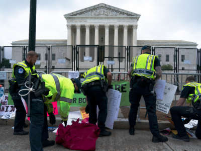 U.S. Capitol police remove banners and signs left at a fence by abortion rights demonstrators outside of the U.S. Supreme Court in Washington, D.C., on May 14, 2022.