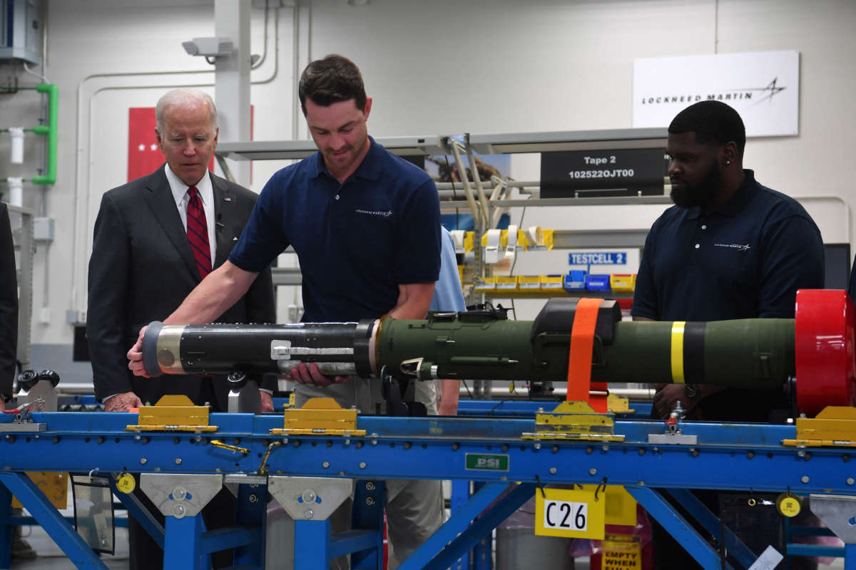 President Joe Biden watches employees as he tours the Lockheed Martins Pike County Operations facility in Troy, Alabama, on May 3, 2022.