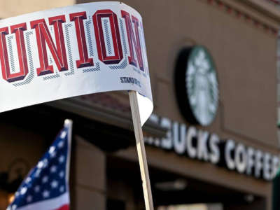 A protester waves a sign that reads 'Union' near the Country Club Plaza Starbucks store where dozens of Starbucks employees and union supporters protested alleged anti-union tactics by the company on March 3, 2022.