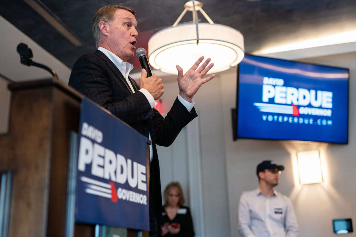 David Perdue speaks into a microphone at a campaign event