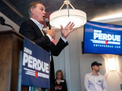 David Perdue speaks into a microphone at a campaign event