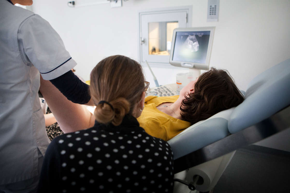 A doctor consults with a couple following an in vitro fertility treatment.