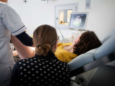 A doctor consults with a couple following an in vitro fertility treatment.