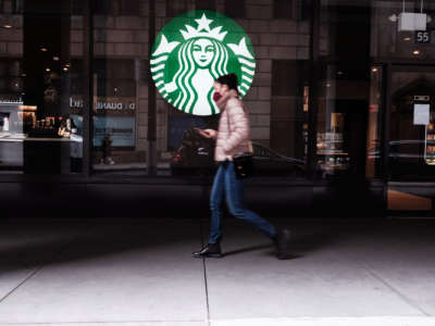 A woman walks by a starbucks location