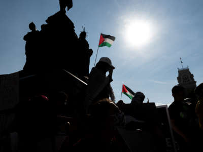 People listen to speakers and hold signs during a pro-Palestine protest on the steps of City Hall on May 23, 2021, in Louisville, Kentucky.