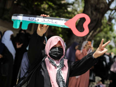 A woman holds up a key during a rally marking the 74th anniversary of what Palestinians call Al-Nakba, or "the catastrophe," which refers to campaign of ethnic cleansing led by Zionist militias that preceded Israel's establishment in 1948, in front of the UNSCO offices in Gaza City, Gaza, on May 15, 2022.