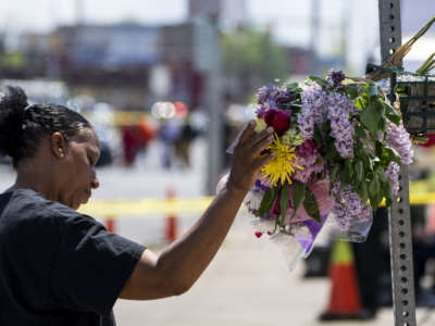 Jeanne LeGall of Buffalo pays her respects at a memorial at Tops Friendly Market on May 15, 2022 in Buffalo, New York, where a white supremacist killed ten people and wounded three others the day before.