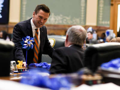 Rep. Cole Wist speaks to Rep. Larry Liston at the Colorado State Capitol in Denver, Colorado, on April 25, 2018.