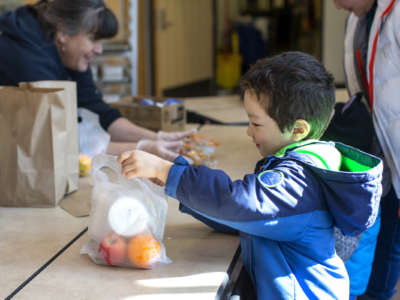 Tyden Brownlee, 5, picks up a free school lunch at Olympic Hills Elementary School on March 18, 2020 in Seattle, Washington.