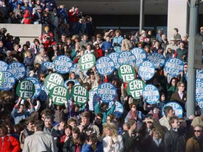 A group of demonstrators in front of the Department of Labor hold signs supporting the Equal Rights Amendment and abortion rights as President Bush passes by in the inaugural parade, on January 20, 1989, in Washington.