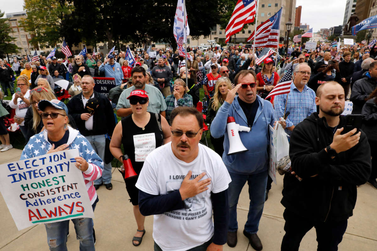 Protesters sing the U.S. National Anthem as they call for a "forensic audit" of the 2020 presidential election, during a demonstration by a group called Election Integrity Fund and Force outside of the Michigan State Capitol, in Lansing, Michigan, on October 12, 2021.