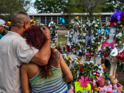 People pay tribute and mourn at a makeshift memorial for the victims of the Robb Elementary School shooting in Uvalde, Texas, on May 31, 2022.