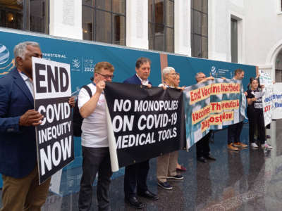 Non-governmental organization members stage a protest in the World Trade Organization headquarters' central atrium during the second day of a WTO Ministerial Conference in Geneva on June 13, 2022.