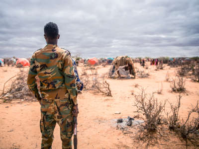 A soldier looks over a refugee camp