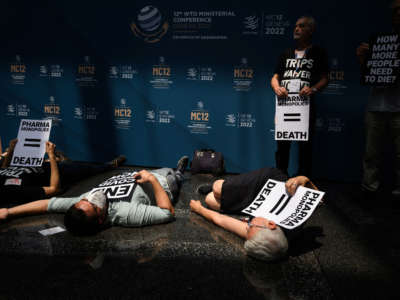 Activists stage a demonstration at the World Trade Organization headquarters's atrium urging government to demand real Trade-Related Aspects of Intellectual Property Rights (TRIPS) waivers during the 12th WTO Ministerial Conference in Geneva, on June 15, 2022.