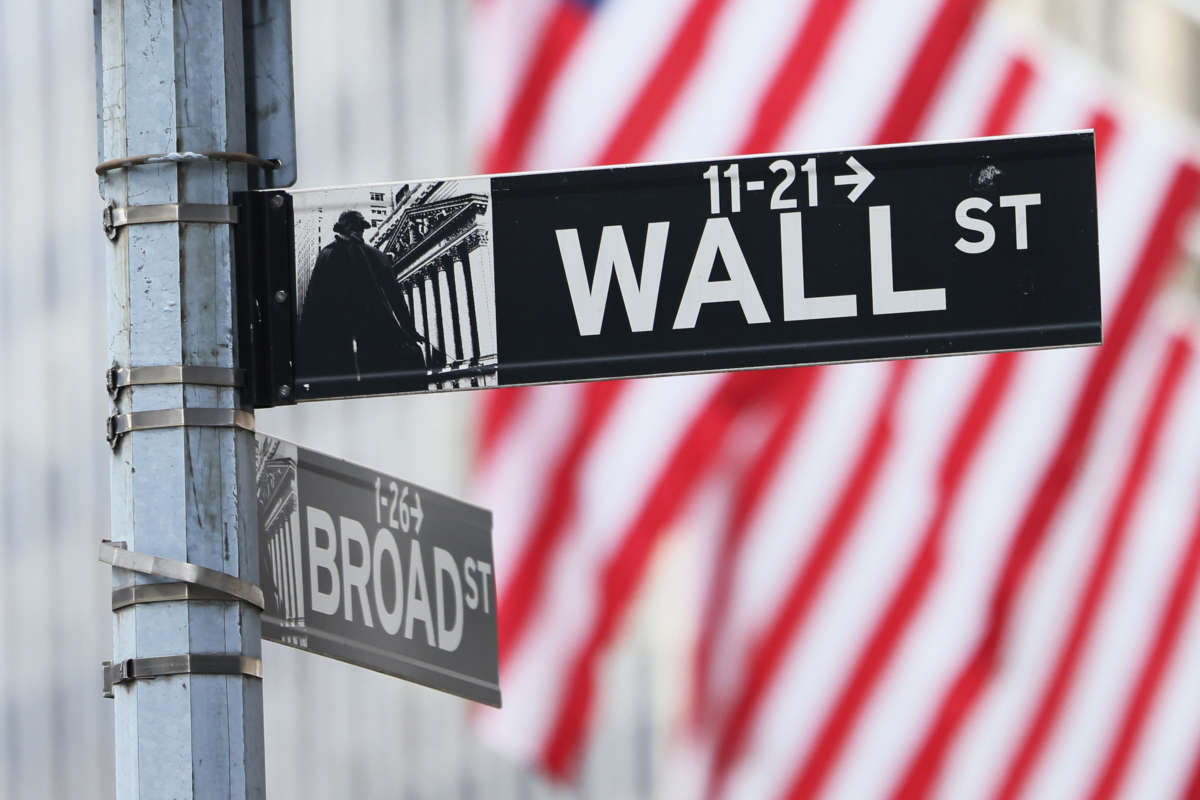 Wall Street sign is seen before American flags