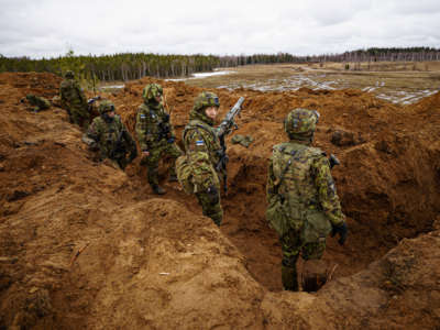 Estonian soldiers defend a dug-in position from attacking British armor and infantry in the Tapa central military training area in Estonia on NATO exercise Bold Dragon alongside Danish and French forces on April 14, 2022.