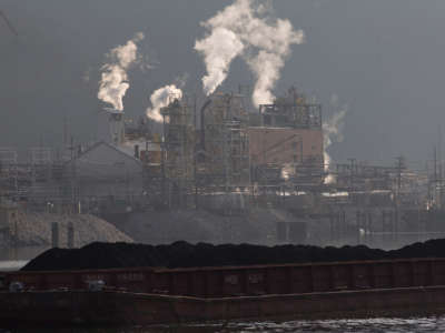 Just south of Charleston, West Virginia, a coal barge travels up the Kanawha River, passing the Dupont chemical plant. West Virginia joined other states and the coal industry in challenging the EPA's authority over air pollution from power plants.