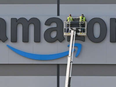 Technicians work on the Amazon logo at the shipping warehouse in a district of the municipality of Schönefeld in the Dahme-Spreewald district of Brandenburg, Germany, on May 3, 2022.