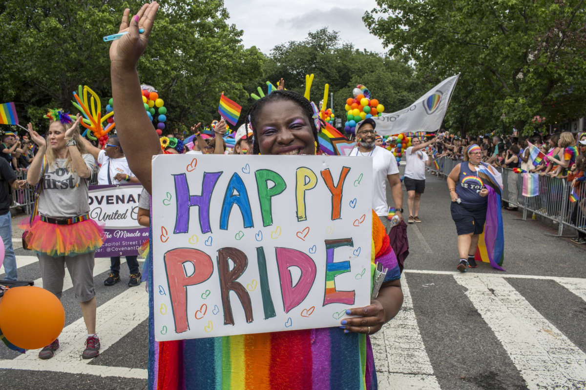 A woman holds a sign with "Happy Pride" written on it during the annual Pride Parade celebrations in Washington, D.C., on June 25, 2022.