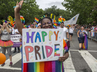 A woman holds a sign with "Happy Pride" written on it during the annual Pride Parade celebrations in Washington, D.C., on June 25, 2022.