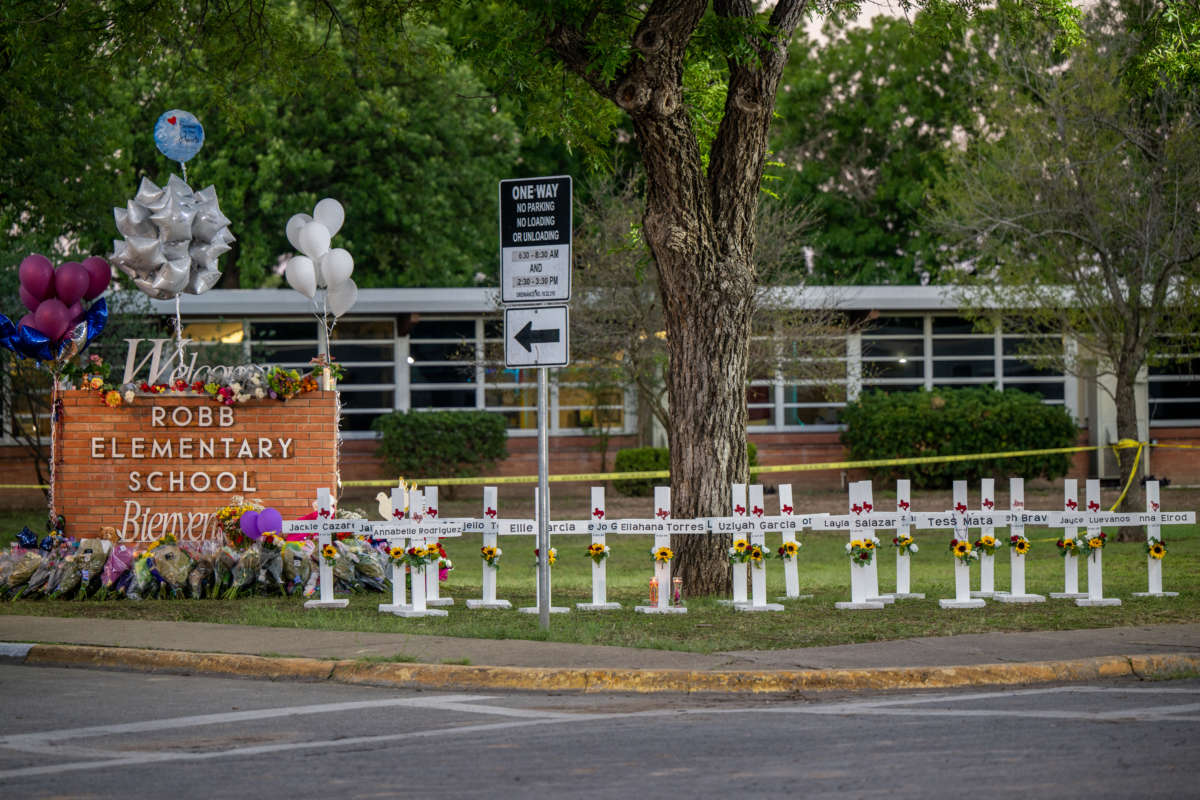 A memorial is seen surrounding the Robb Elementary School sign following the mass shooting at Robb Elementary School on May 26, 2022, in Uvalde, Texas.