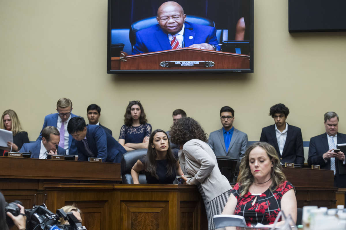 Rep. Alexandria Ocasio-Cortez (D-New York) talks with an aide during the House Oversight and Reform Committee hearing in Rayburn Building on Friday, July 12, 2019.