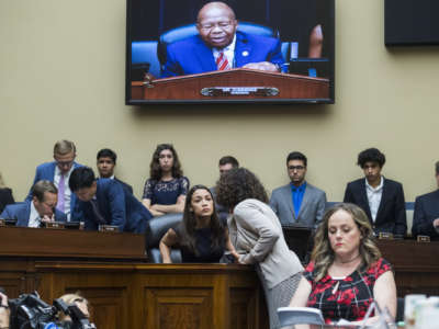 Rep. Alexandria Ocasio-Cortez (D-New York) talks with an aide during the House Oversight and Reform Committee hearing in Rayburn Building on Friday, July 12, 2019.