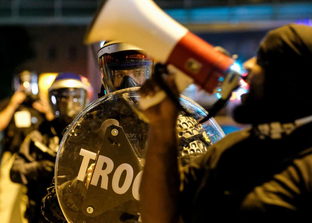 Troopers in riot gear watch as demonstrators gather outside Akron City Hall to protest the killing of Jayland Walker, shot by police, in Akron, Ohio, on July 3, 2022.