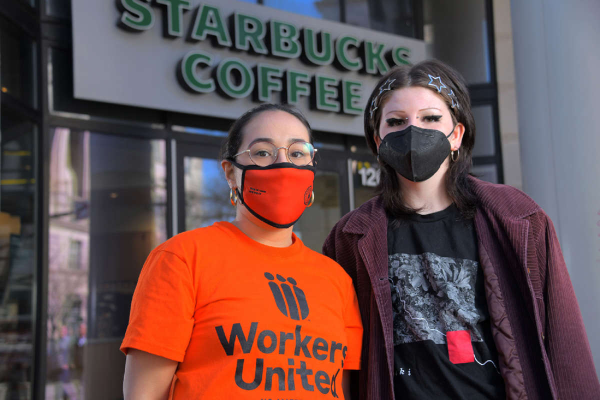 Stephanie Hernandez, organizer with Workers United (left) and Kieren Levy, a barista who works at the Mount Vernon Starbucks on North Charles Street pose outside the establishment.