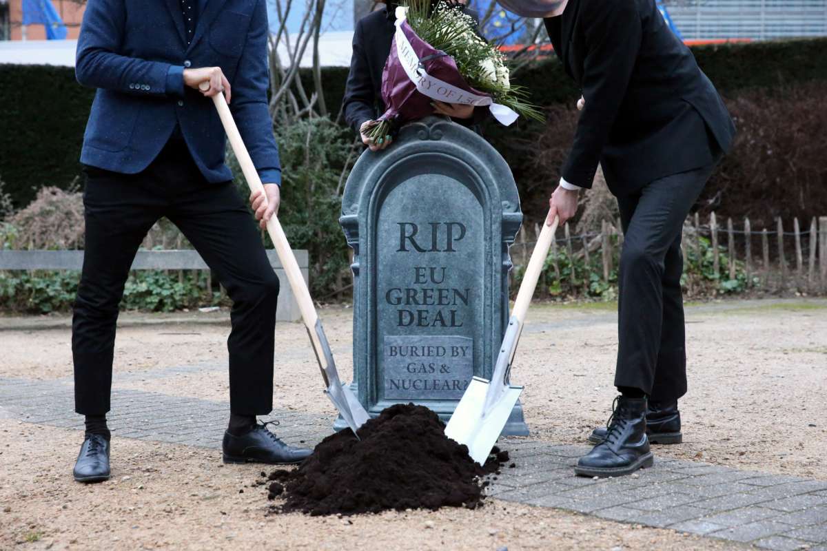 Activists dig a pretend grave with a headstone that reads "RIP EU GREEN DEAL; BURIED BY GAS AND NUCLEAR"