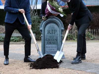 Activists dig a pretend grave with a headstone that reads "RIP EU GREEN DEAL; BURIED BY GAS AND NUCLEAR"