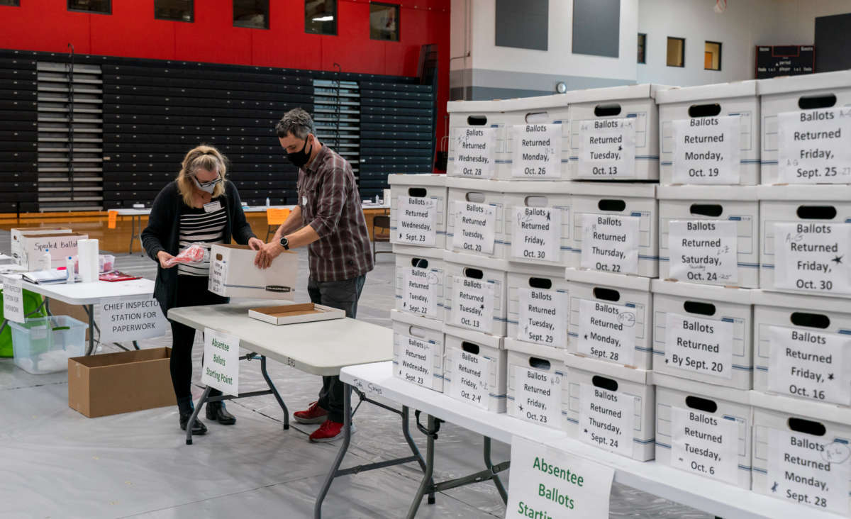 Poll workers check-in a box of absentee ballots in the gym at Sun Prairie High School on November 3, 2020, in Sun Prairie, Wisconsin.