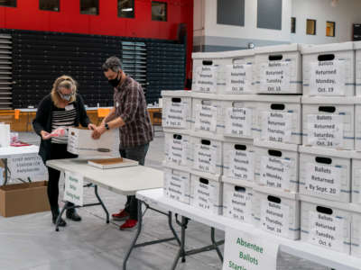 Poll workers check-in a box of absentee ballots in the gym at Sun Prairie High School on November 3, 2020, in Sun Prairie, Wisconsin.