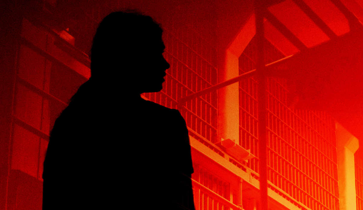 Woman prisoner silhouette over prison cells in orange