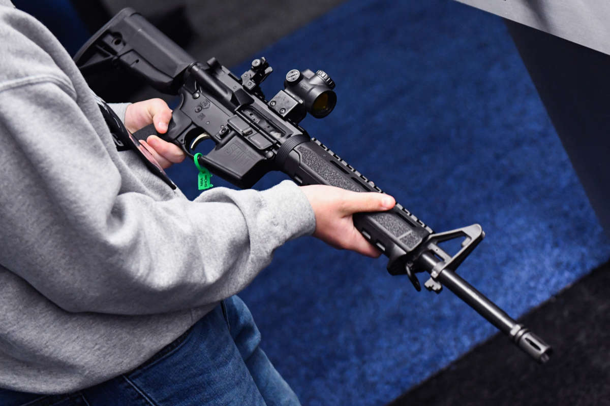 A man holds a large rifle