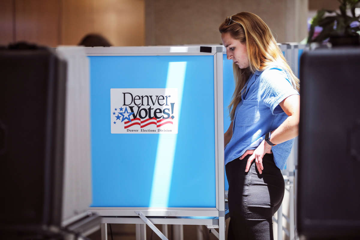 A woman votes at a booth