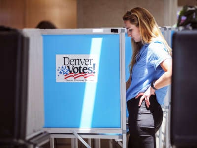 A woman votes at a booth