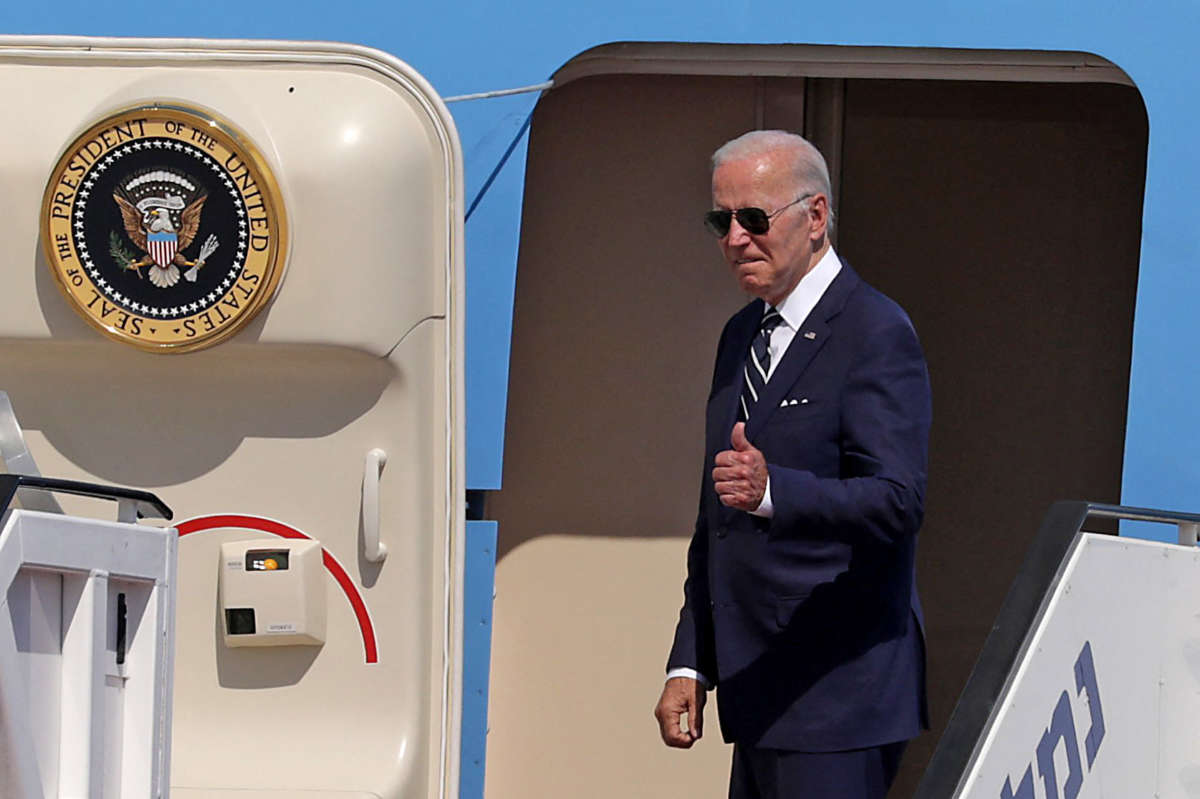 Joe Biden makes a thumbs up at someone out of frame while boarding air force one