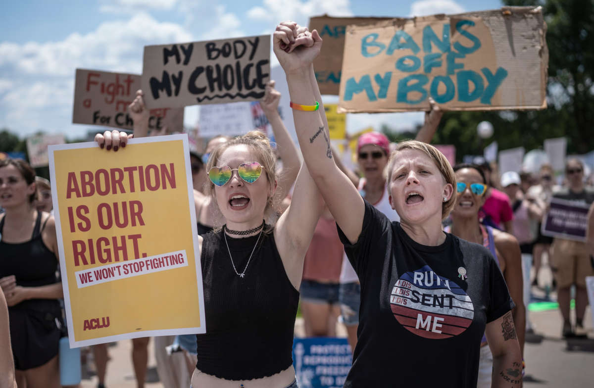 McKayla Wolff, left, and Karen Wolff join hands as they rally for abortion rights in St. Paul, Minnosota, on July 17, 2022.